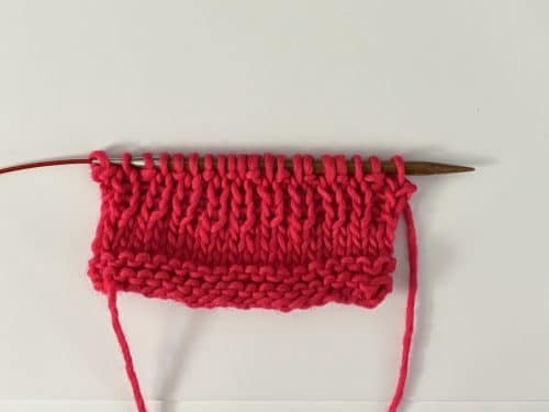 Cast On + 3 rows of garter stitch + 4 rows of stockinette + 4 rows of 1x1 ribbing Yarn: Manos del Uruguay Maxima in Speeding Ticket Needles: ChiaoGoo bamboo size 8 needles on a red cable.